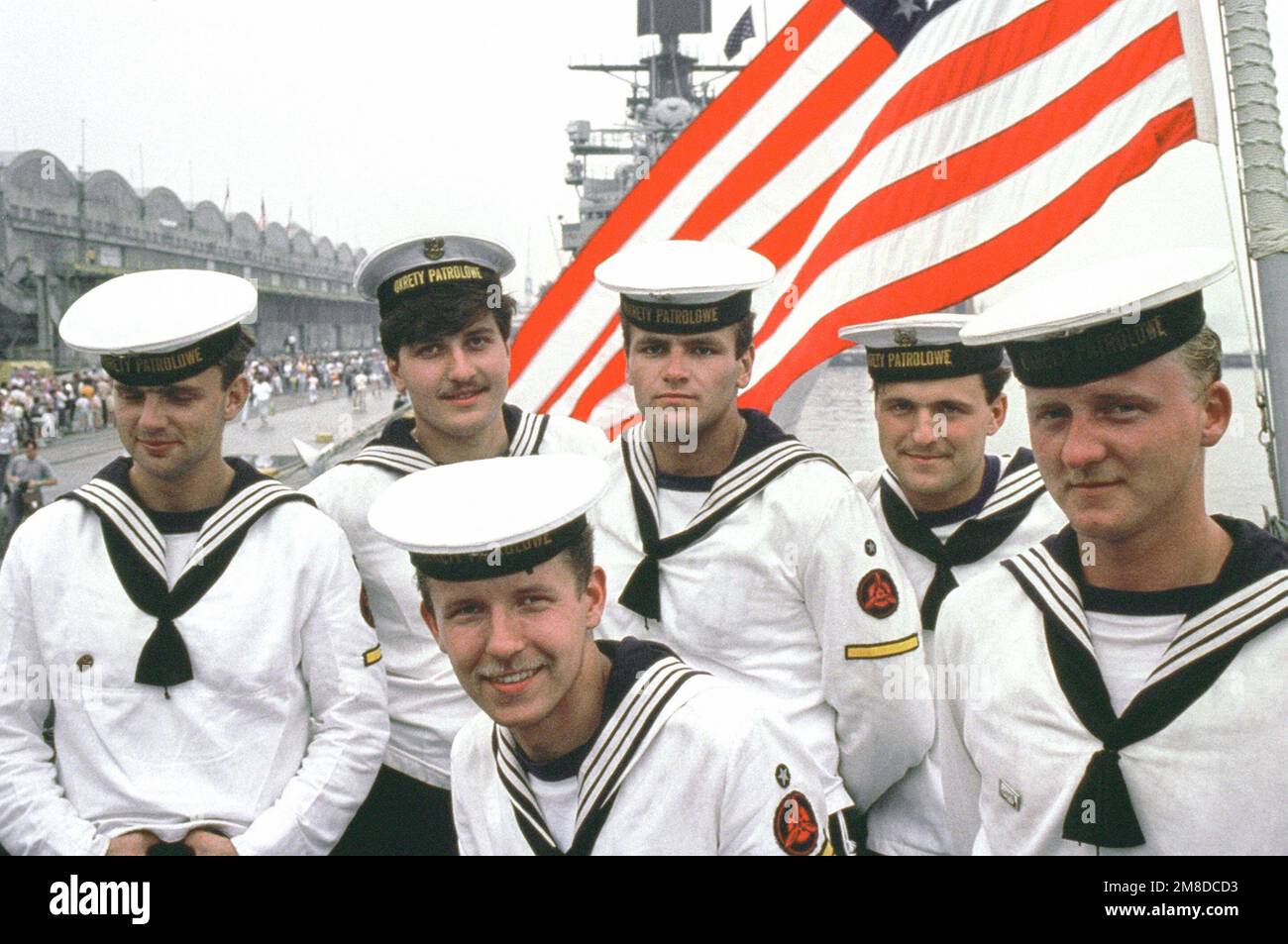 Polish sailors pose for a photo under the American flag as they tour