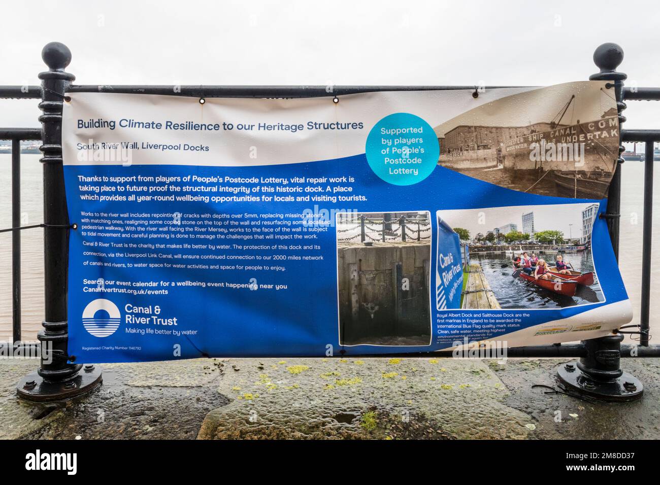 Canal & River Trust sign on Liverpool waterfront explaining work to build climate resilience into dock structure. Stock Photo