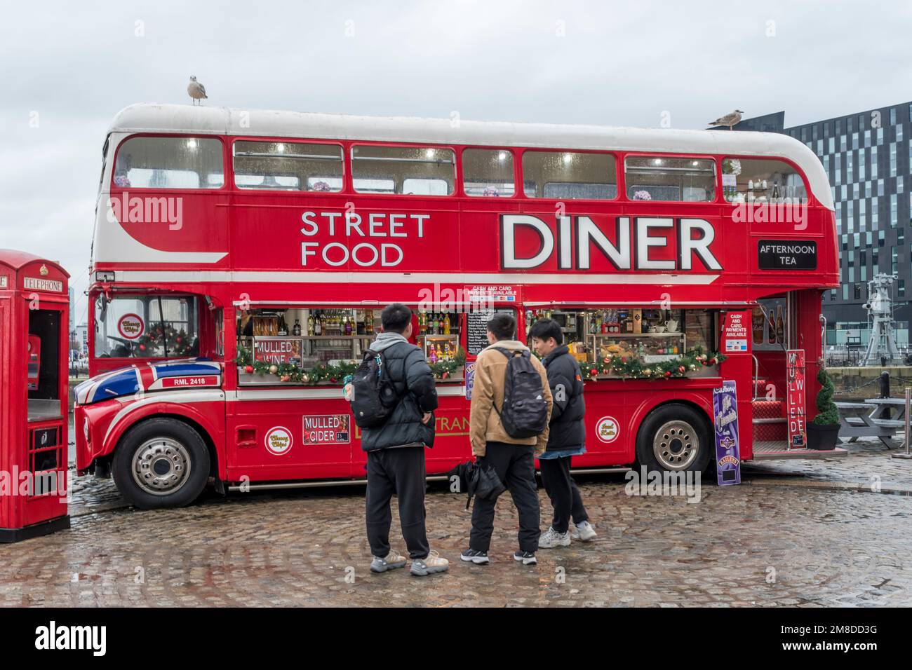 Red double-decker bus repurposed as a street food Diner at Liverpool's Albert Dock. Stock Photo