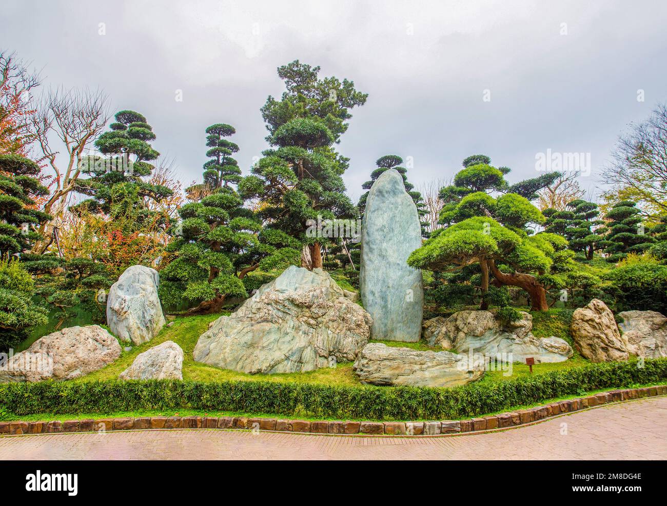 Superb View of the cliffs in Nan Lian Park with idyllic topiary podocarpus and pine trees. Entrance to the garden шn tropical Hong Kong. Interesting l Stock Photo