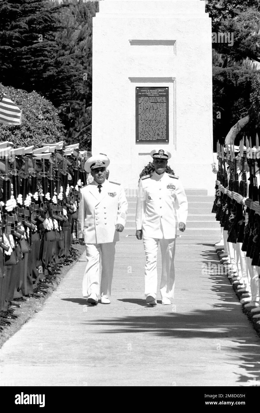 U.S. Marines and Soviet sailors present arms as ADM Gennidiy Khvatov, left, commander, Soviet Pacific Fleet, and ADM Charles R. Larson, commander in chief, U.S. Pacific Fleet, walk between them during a wreath-laying ceremony at Fort Rosecrans National Cemetery. The ceremony is being held to honor those members of the U.S. Merchant Marine who died while delivering supplies to the Soviet Union during World War II. Three ships of the Soviet Pacific Fleet are in San Diego for a five-day goodwill visit. Base: San Diego State: California (CA) Country: United States Of America (USA) Stock Photo