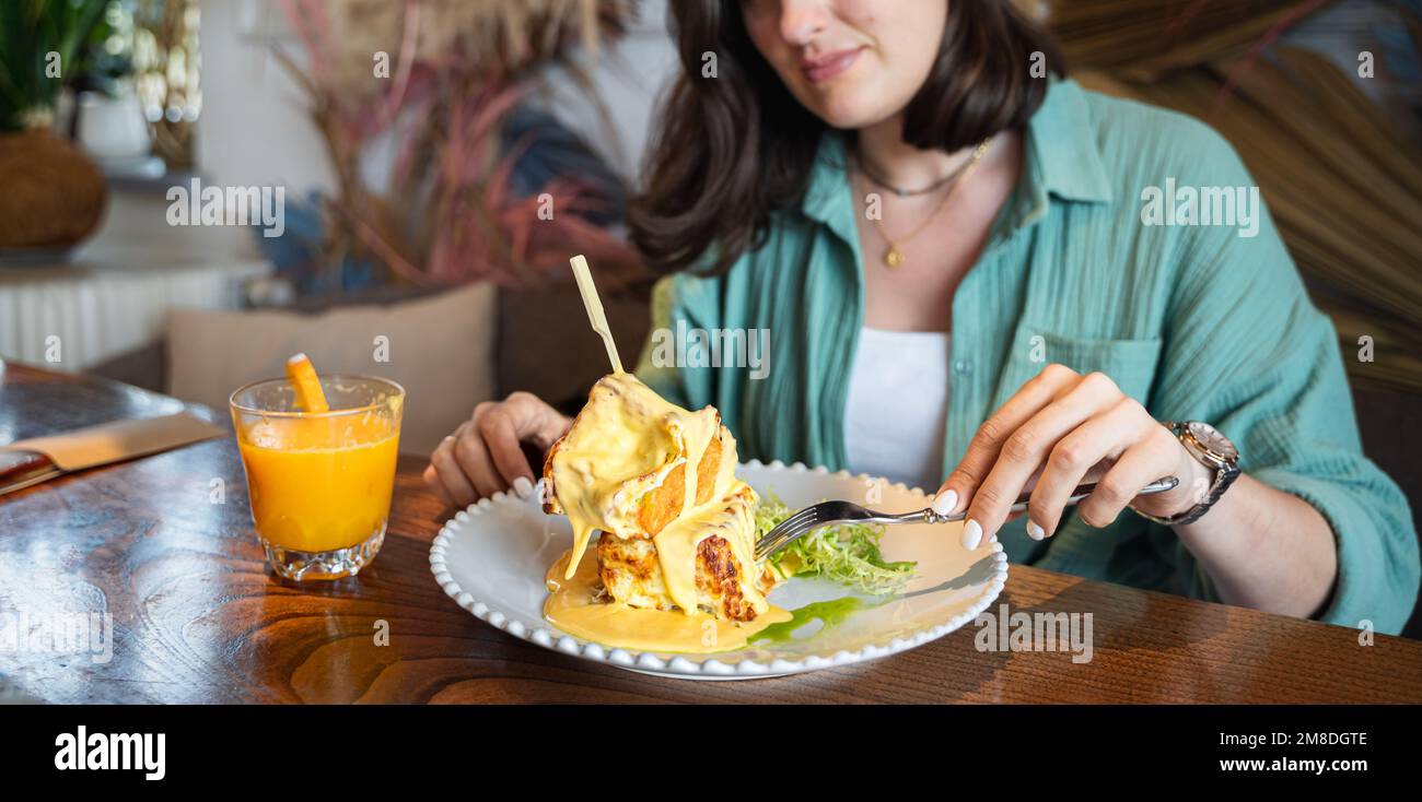 Trendy breakfast in hipster restaurant, cafe. Creative square-shaped croissant in form of cube on skewer. Served with hot cheese in small gravy boat, Stock Photo