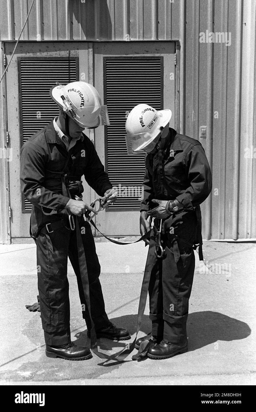 Jim Krebs, left, helps Mike Leija put on a rappelling harness. Members