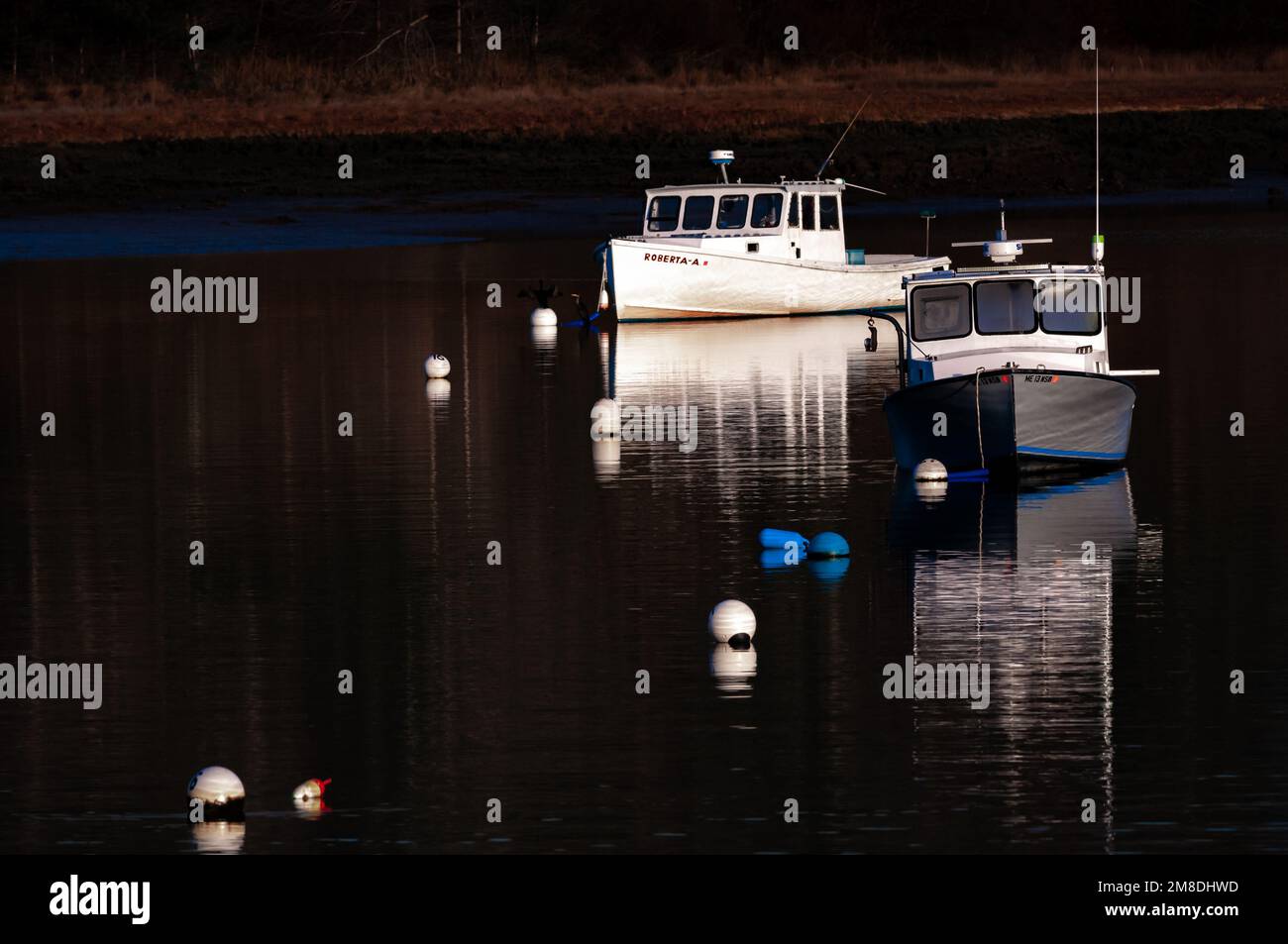 On a very cold winter afternoon as the Sunsets. These two lobster boats are moored alone until Spring when all the other boats will be back. Stock Photo