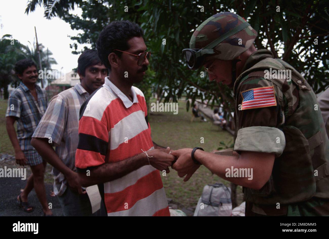 A Marine checks the manifest ticket of a man waiting to board a