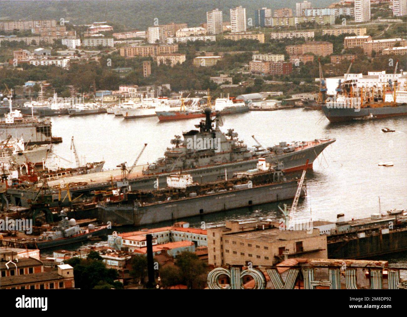 A view of the Soviet Kiev class aircraft carrier MINSK, center, and other Soviet naval and merchant ships tied up in the city's harbor. The Minsk is in Vladivostok for repairs. Base: Vladivostok State: Siberia Country: U.S.S.R. (SUN) Stock Photo
