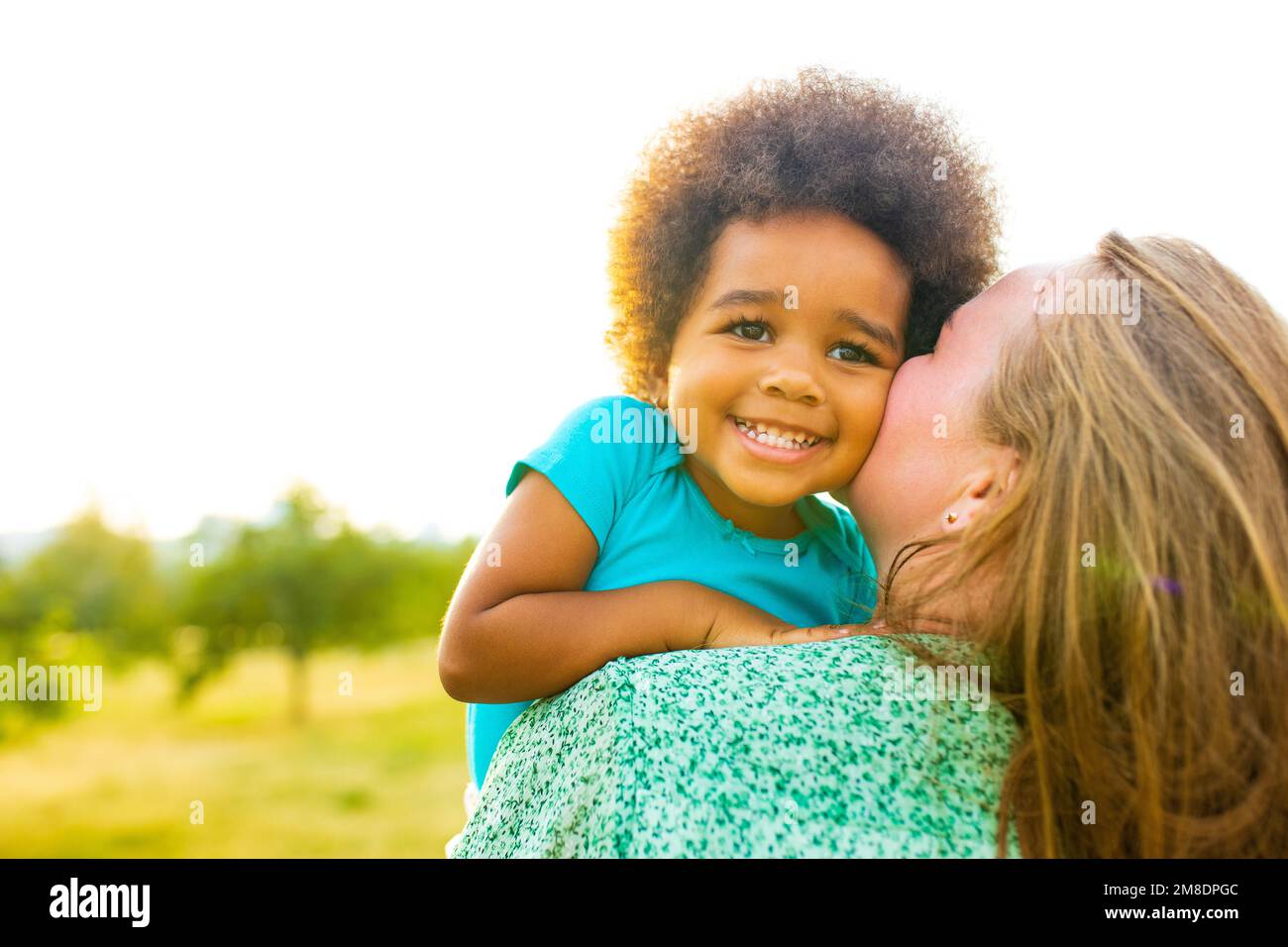 little girl with cool afro curly hair having fun together with mom