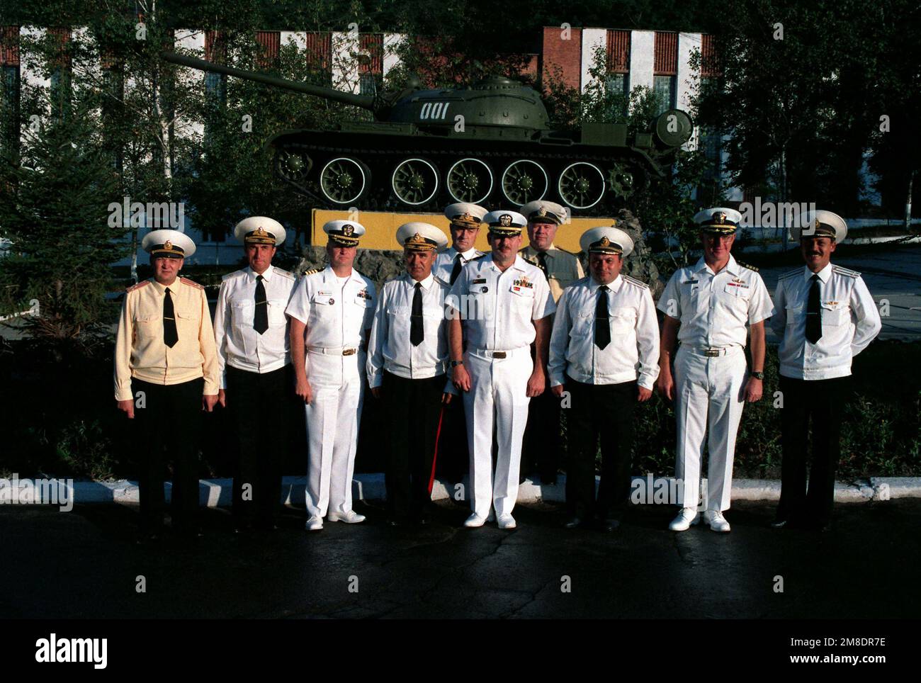 American and Soviet officers gather for a photograph in front of a T-54 tank at a Soviet navy service school during a visit to the city by two US Navy ships. The guided missile cruiser USS PRINCETON (CG-59) and the guided missile frigate USS REUBEN JAMES (FFG 57) are in Vladivostok for four days as part of a goodwill exchange program. Base: Vladivostok State: Siberia Country: U.S.S.R. (SUN) Stock Photo
