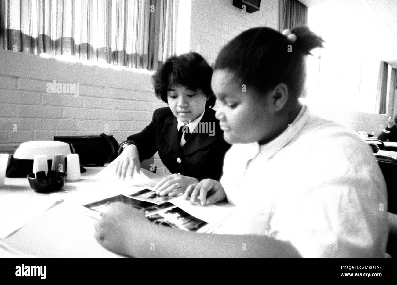 ENSIGN Janet A. Silvano, Naval Military Personnel Command, tutors an inner city minority student in the 'Navy Kids' program. Base: Washington State: District Of Columbia (DC) Country: United States Of America (USA) Stock Photo