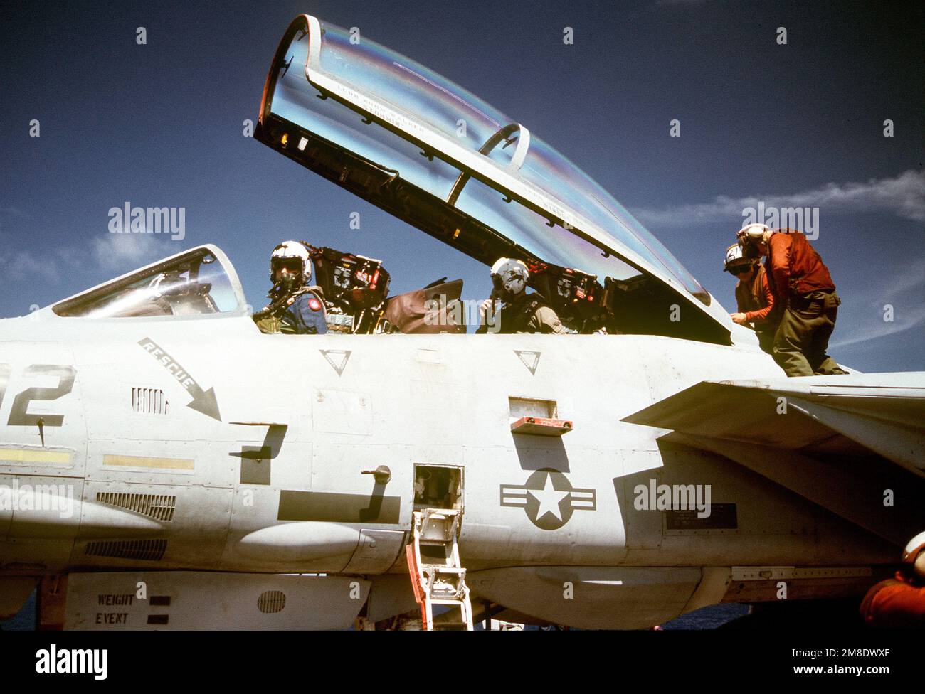 Two maintenance crewmen work on a Fighter Squadron 213 (VF213) F14A