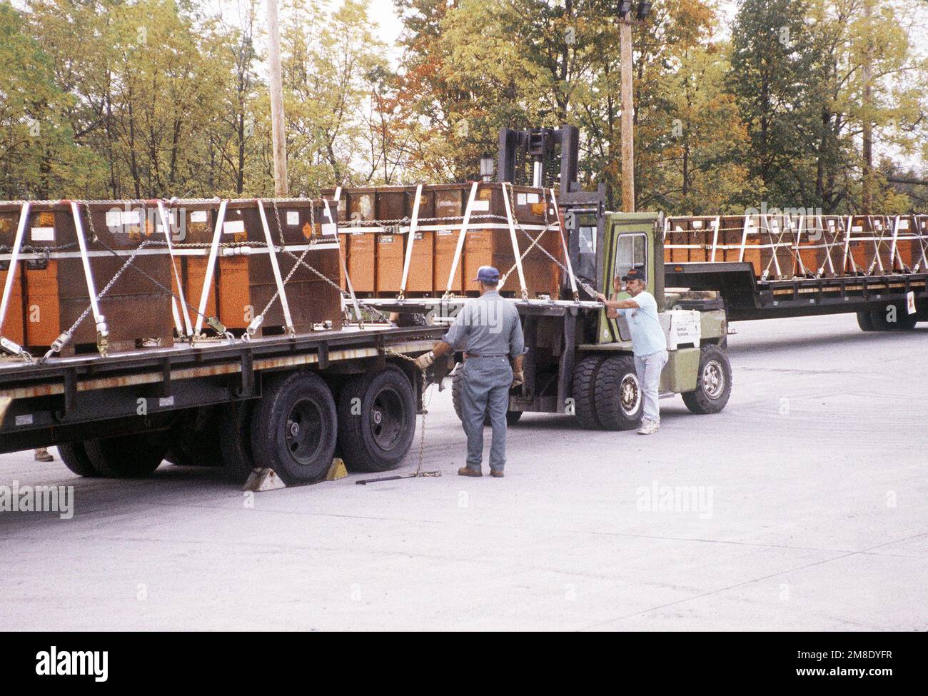 Ammunition operations personnel load trailers with containers of 30mm high explosive incendiary (HEI) ammunition. The containers will be placed on a C-141B Starlifter aircraft for shipment to the Persian Gulf area during Operation Desert Shield. Subject Operation/Series: DESERT SHIELD Base: Seneca Army Depot, Romulus State: New York (NY) Country: United States Of America (USA) Stock Photo