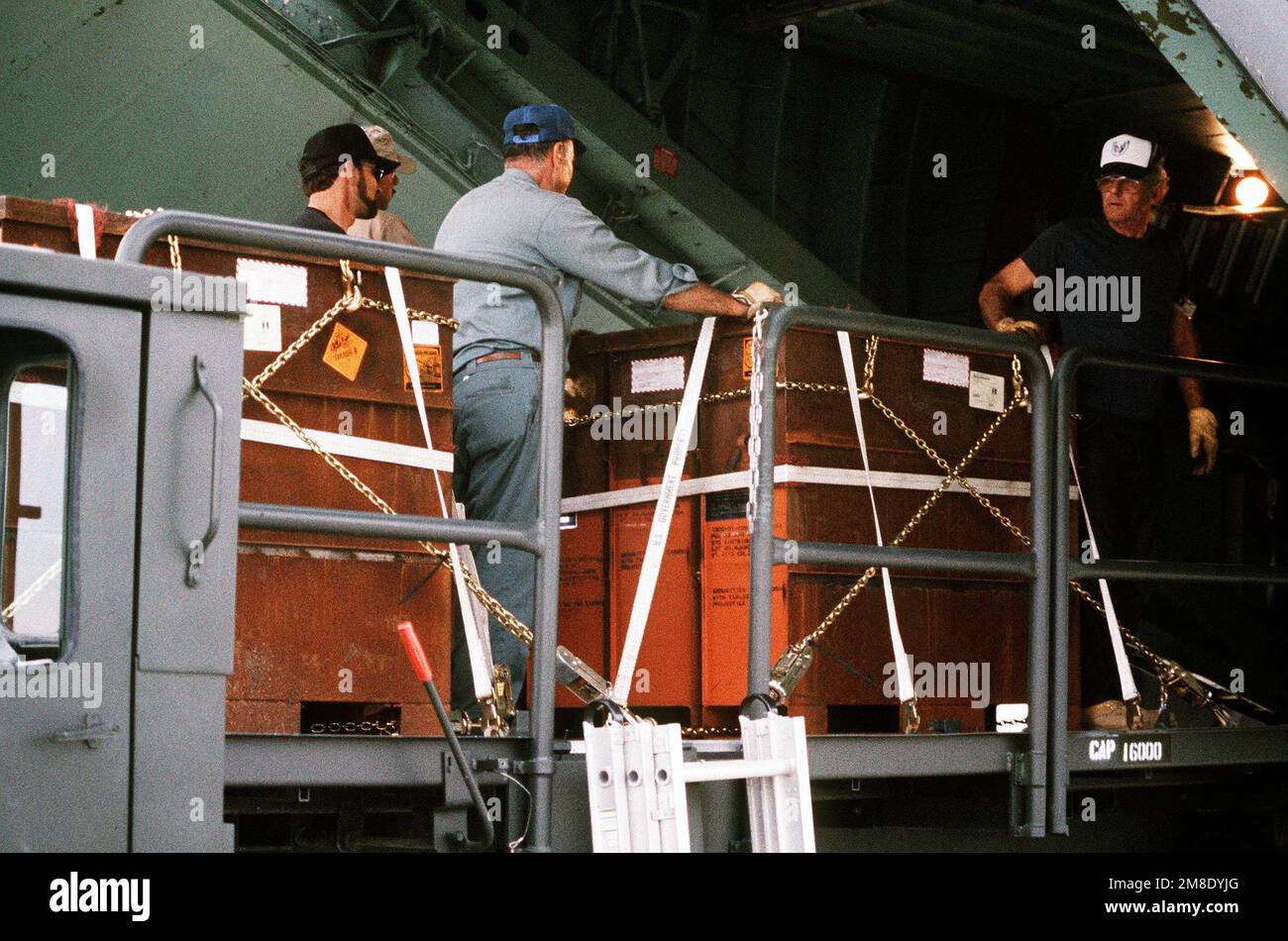 Edward Mitchell, Jim Jones and Bill Benkovich, all ammunition operations personnel, load a C-141B Starlifter aircraft with containers of 30mm high explosive incendiary (HEI) ammunition bound for the Persian Gulf area during Operation Desert Shield. Subject Operation/Series: DESERT SHIELD Base: Seneca Army Depot, Romulus State: New York (NY) Country: United States Of America (USA) Stock Photo