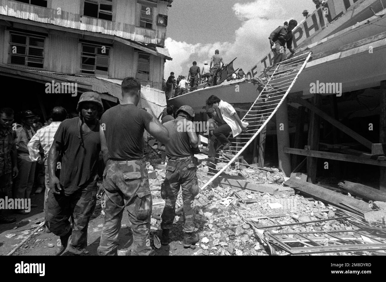 Rescue workers, assisted by members of a United States Marine