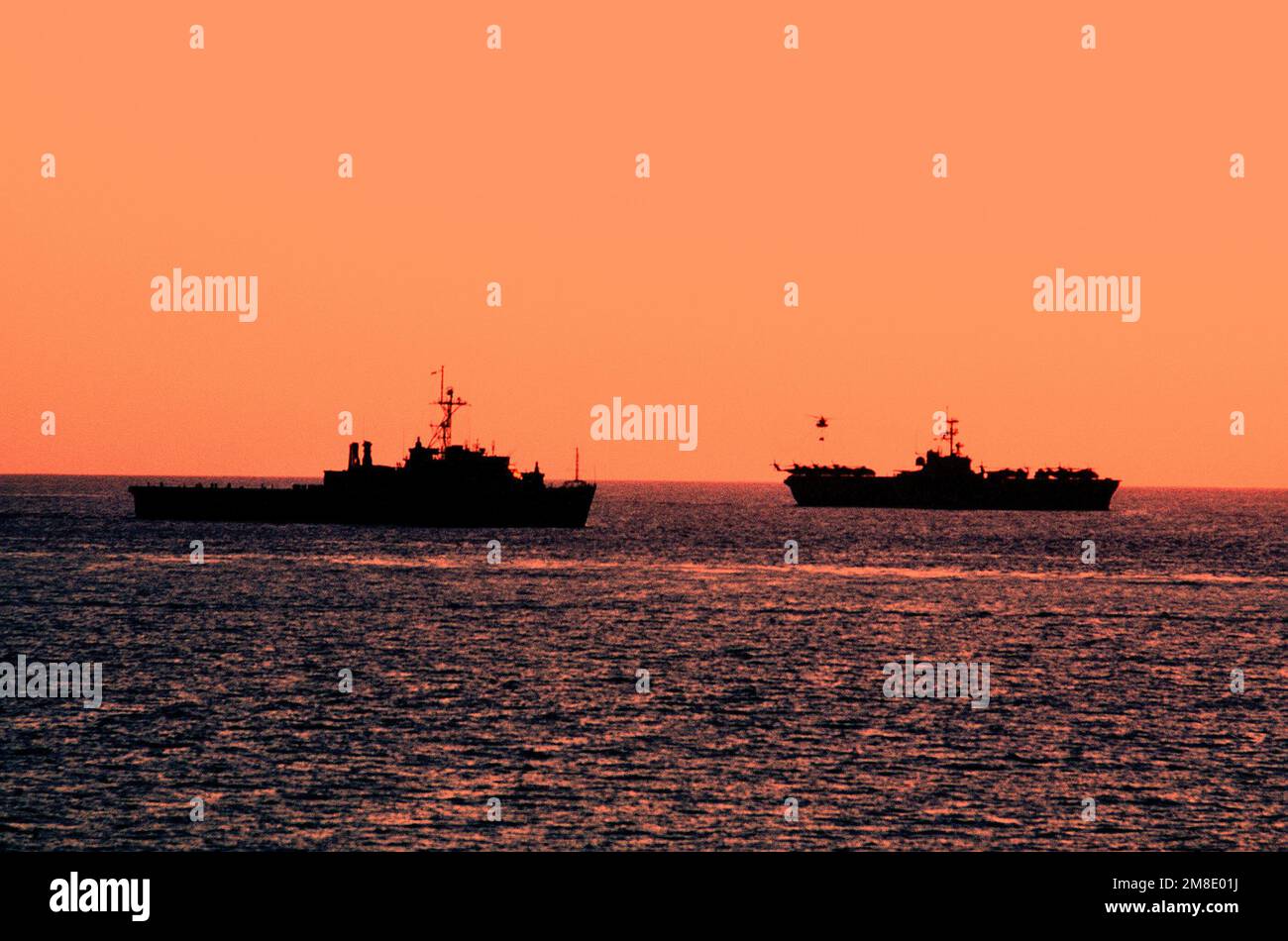 An Austin class amphibious transport dock, left, and an Iwo Jima class