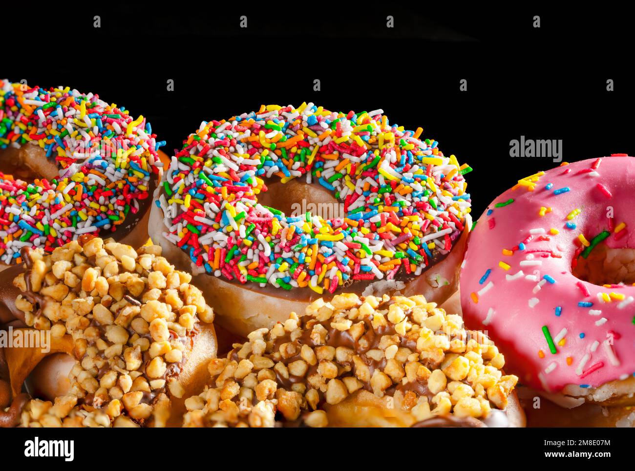 Sprinkled donuts closeup with black negative space ideal for website publication or menu Stock Photo