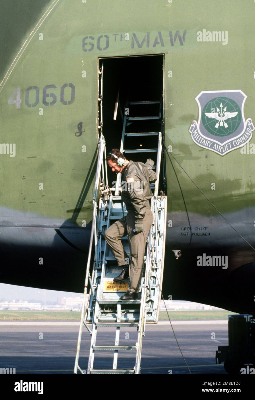 An airman stands on the steps of a 60th Military Airlift Wing C-5B Galaxy aircraft as it is prepared for departure. The aircraft will be flying to Prague, Czechoslovakia, where it will deliver 130,000 pounds of donated medical supplies to the Czech government for distribution. Base: Rhein-Main Air Base Country: Deutschland / Germany(DEU) Stock Photo
