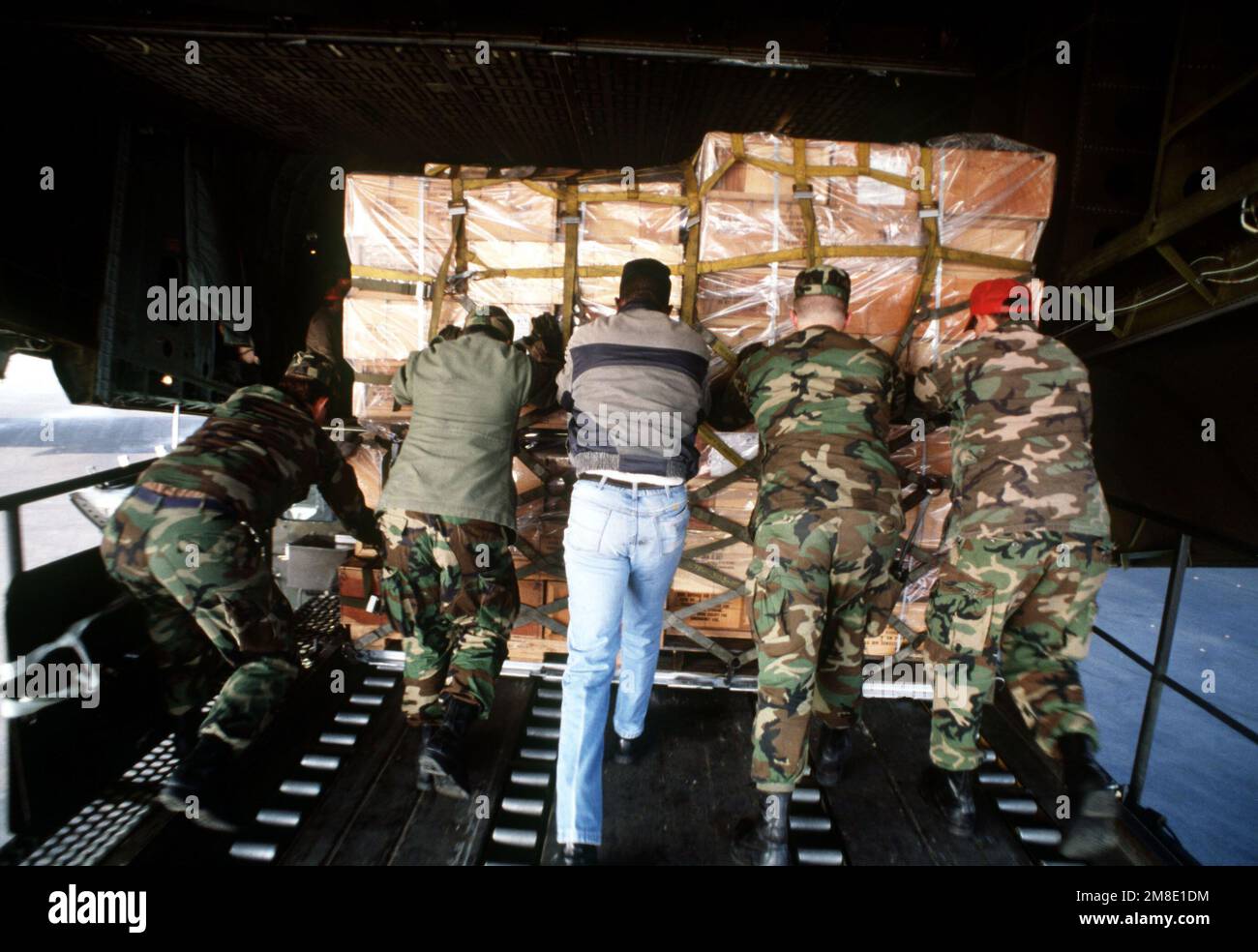 Airmen from the 435th Aerial Port Squadron push a pallet of donated medical supplies onto a 60th Military Airlift Wing C-5B Galaxy aircraft. The aircraft will be flying to Prague, Czechoslovakia, where it will be deliver the supplies to the Czech government for distribution. Base: Rhein-Main Air Base Country: Deutschland / Germany(DEU) Stock Photo