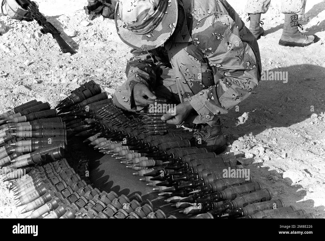 PFC R. Thompson of Company C, 1ST Light Armored Infantry (LAI) Battalion, lays out a belt of 7.62mm machine gun ammunition on top of a belt of 25mm chain gun ammunition during Operation Desert Shield.. Subject Operation/Series: DESERT SHIELD Country: Saudi Arabia(SAU) Stock Photo