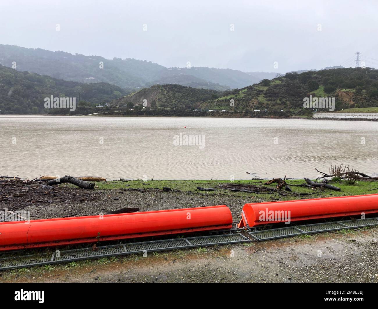 Orange floating debris boom, barrier on ground of reservoir during the rainy season. Stock Photo