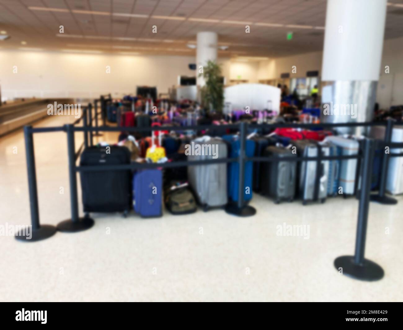 Unclaimed luggage is piling up at the airport arrival terminal due to canceled or delayed flights Abstract blur Stock Photo