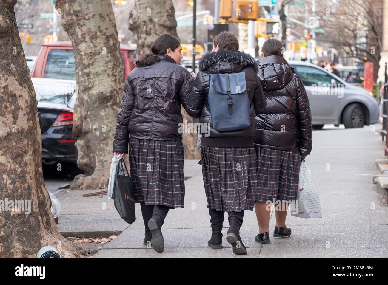 3 unidentified orthodox Jewish girls head home from school wearing the same uniforms. In Brooklyn, New York. Stock Photo