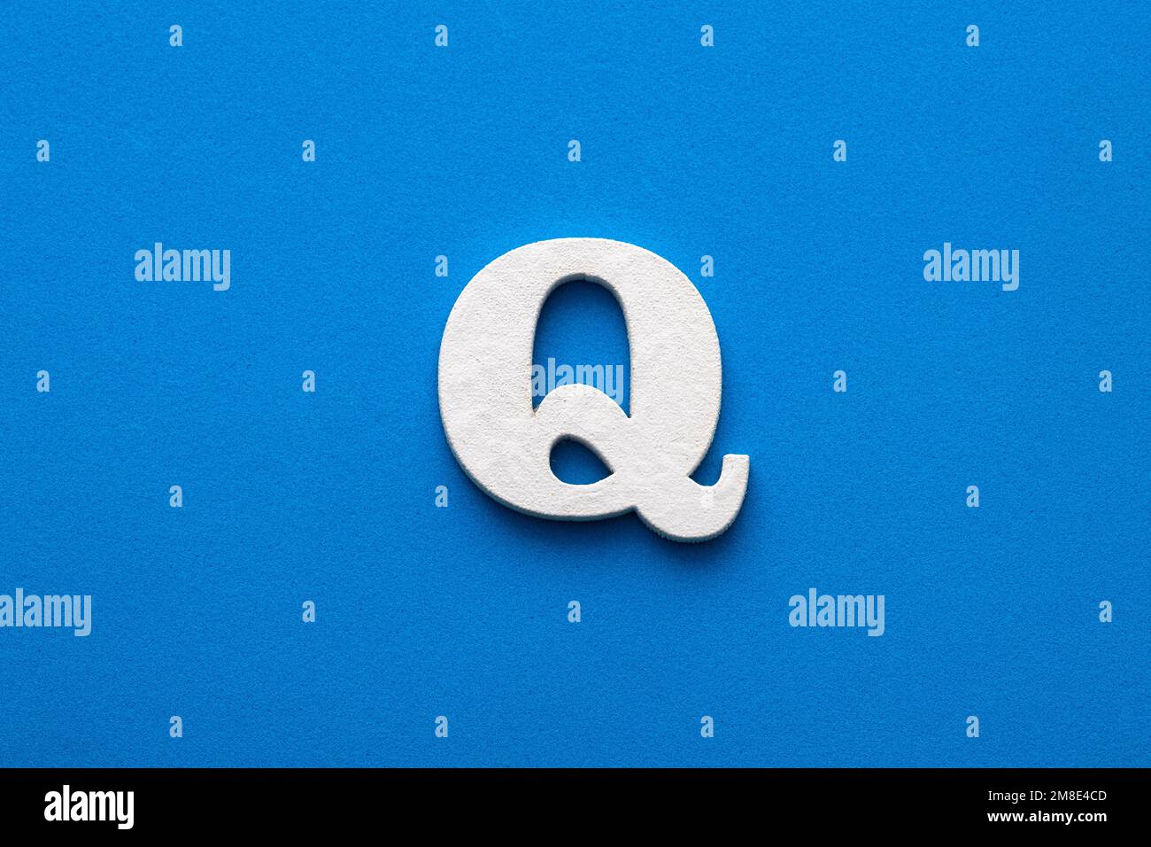 Letter Q uppercase - White wood font on blue foamy background Stock Photo