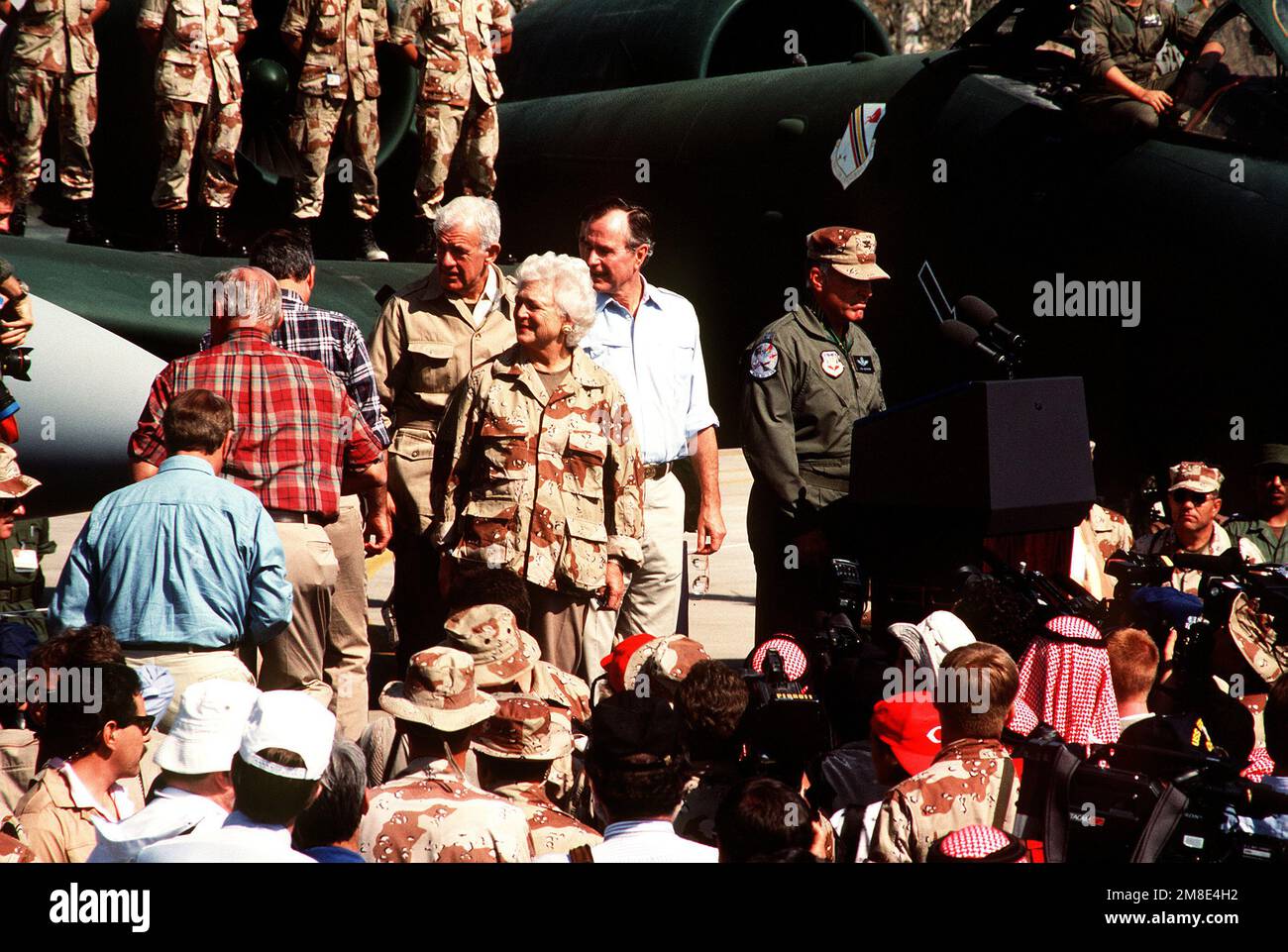 President George Bush and his wife, Barbara, stand beside an Air Force ...