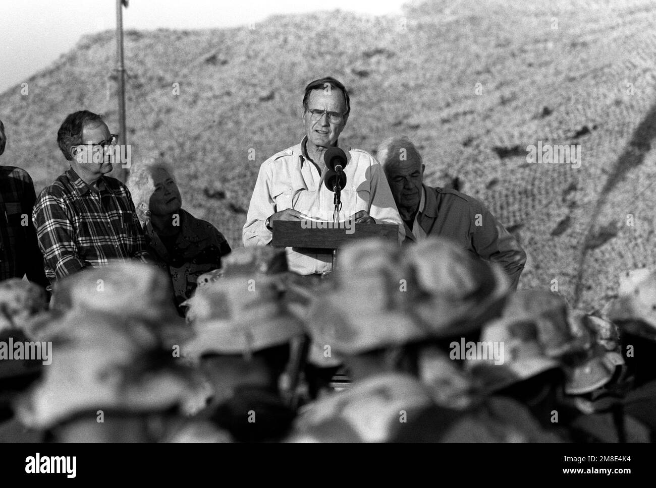 President George Bush speaks to the Marines gathered at the 1ST Marine Division combat operations center (COC) on Thanksgiving Day during Operation Desert Shield. Standing with the president are House Minority Leader Robert H. Michel, left, first lady Barbara Bush, and Speaker of the House Tom Foley, right.. Subject Operation/Series: DESERT SHIELD Country: Saudi Arabia(SAU) Stock Photo