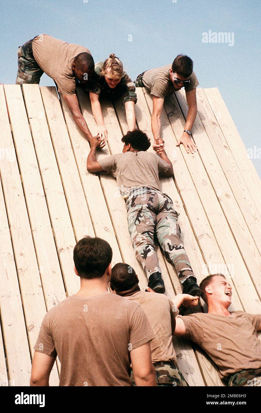 A soldier is hoisted over a barrier as a U.S. Army personnel