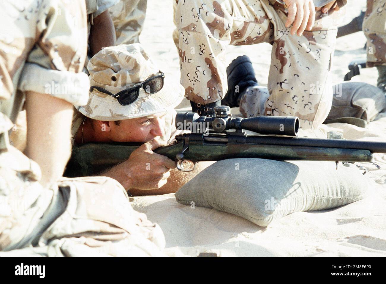 A British soldier from the Queen's Dragoon Guards fires an M-40A1 sniping rifle while taking part in weapons training with Marines from 7th Platoon, 1ST Force Reconnaissance Company, at Abu Hydra Range during Operation Desert Shield. Subject Operation/Series: DESERT SHIELD Country: Saudi Arabia (SAU) Stock Photo