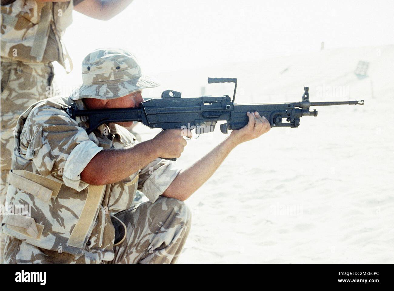 A British soldier from the Queen's Dragoon Guards fires an M-249 squad automatic weapon (SAW) while participating in weapons training with the Marines of 7th Platoon, 1ST Force Reconnaissance Company, at Abu Hydra Range during Operation DESERT SHIELD. Subject Operation/Series: DESERT SHIELD Country: Saudi Arabia (SAU) Stock Photo