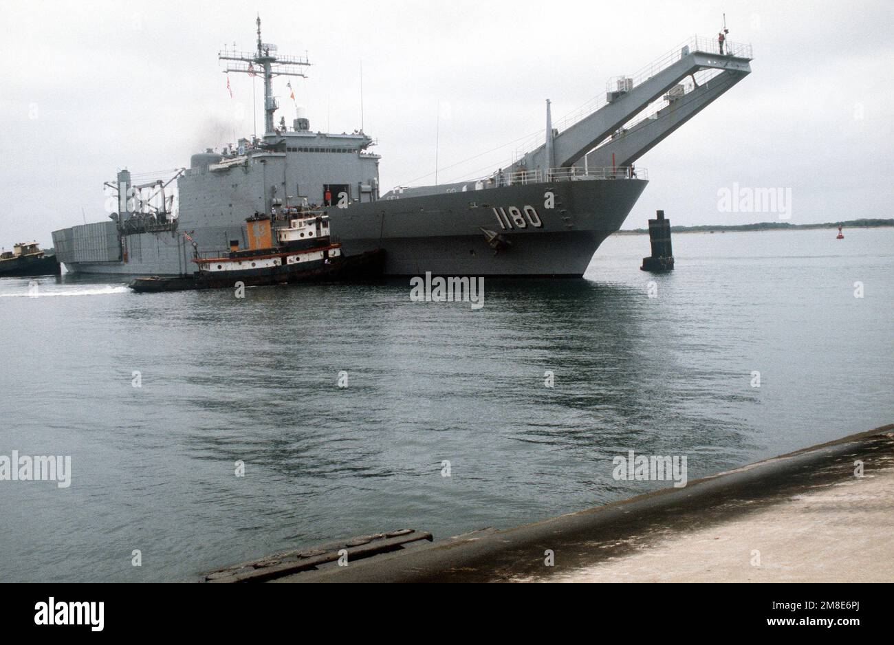 Harbor tugs position the tank landing ship USS MANITOWOC (LST 1180 ...