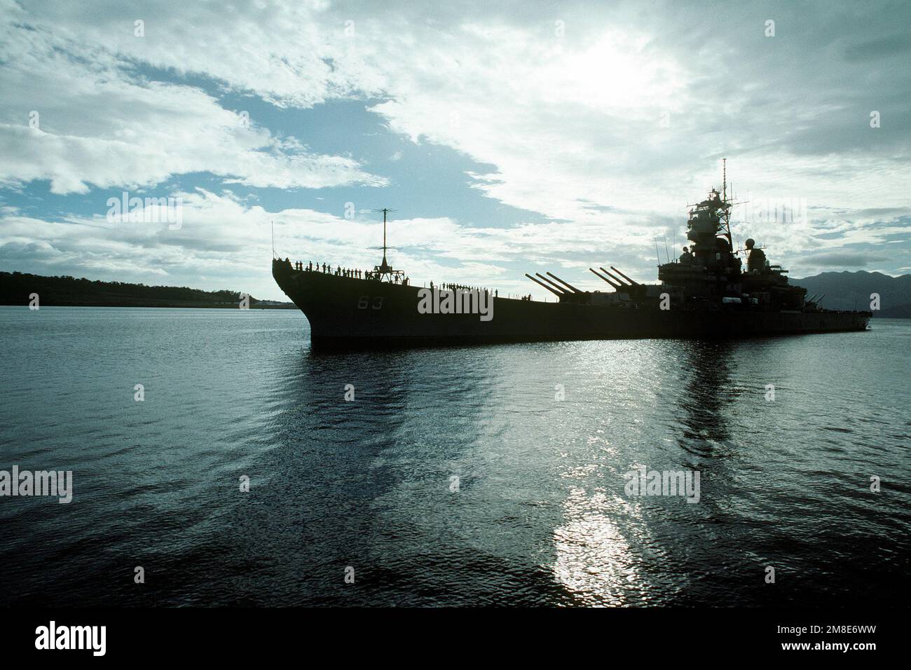 Crew members watch from the railing as the battleship USS MISSOURI (BB ...