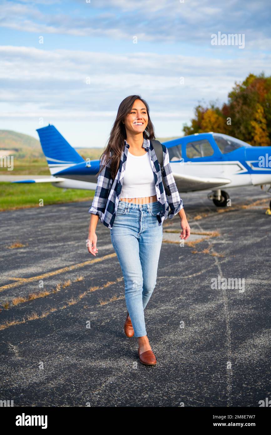 Young BIPOC Female Pilot preparing to travel by small airplane Stock Photo