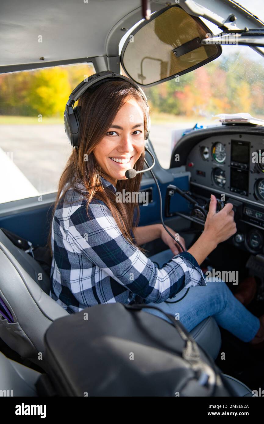 Young BIPOC Female Pilot preparing to travel by small airplane Stock Photo