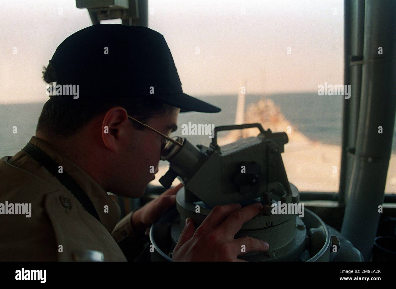 An officer aboard the battleship USS WISCONSIN (BB-64) takes a reading with a telescopic alidade. The WISCONSIN is part of the U.S. Navy force in the gulf supporting Operation Desert Shield. Subject Operation/Series: DESERT SHIELD Country: Unknown Stock Photo