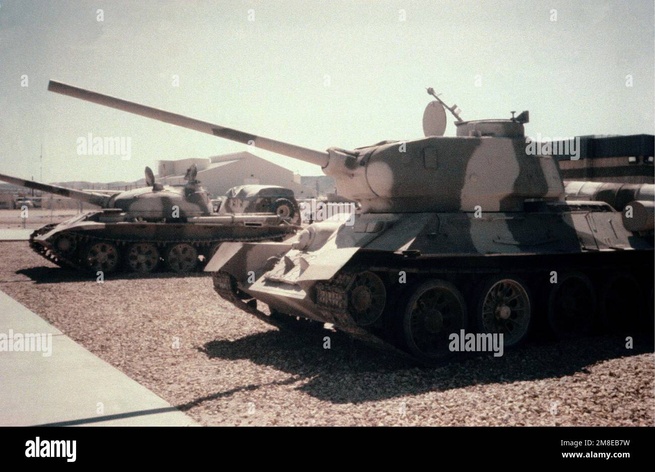 Left front view, on display, Soviet T34/85 Medium Tank. Soviet T-62 Main Battle Tank in background. Country: Unknown Stock Photo