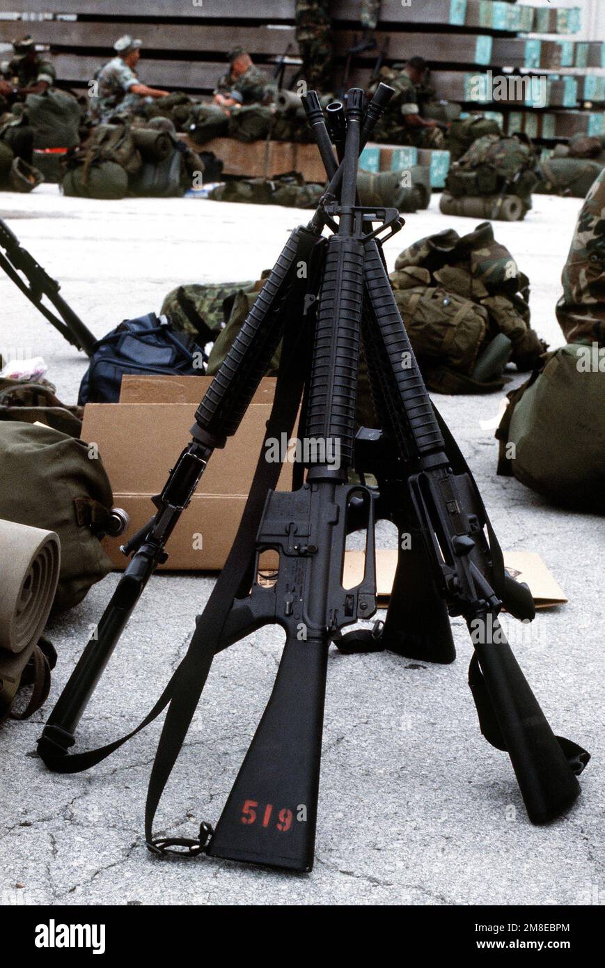Four M-16A2 rifles are arranged at stack arms on the pier among the ...
