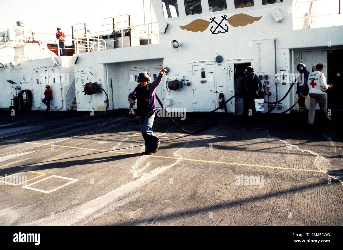 Aviation fuels crew members carry a hose on the flight deck of the hospital ship USNS COMFORT (T