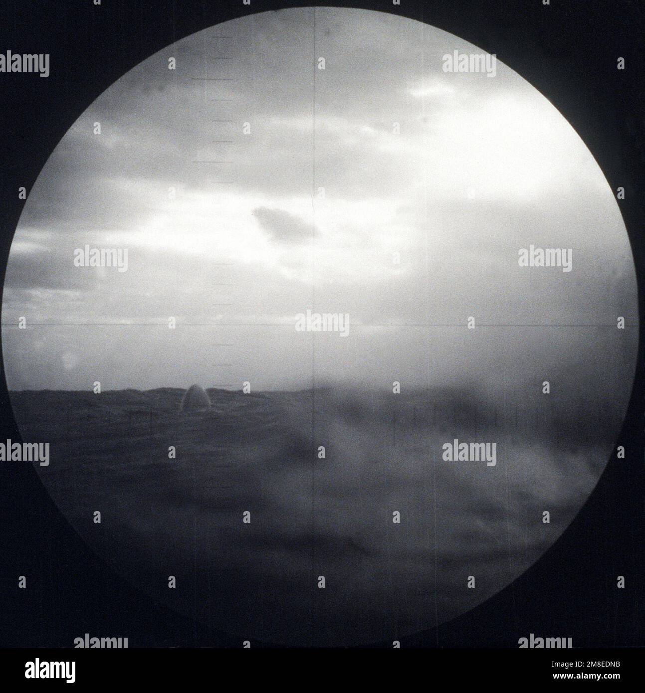 As seen through the submarine's periscope, the nose of a BGM-109 Tomahawk Land Attack Missile (TLAM) targeted on an Iraqi position emerges from the water after being fired from a vertical launch tube aboard the nuclear-powered attack submarine USS PITTSBURGH (SSN-720) during Operation Desert Storm. (First in a series of nine views.). Subject Operation/Series: DESERT STORM Country: Unknown Stock Photo