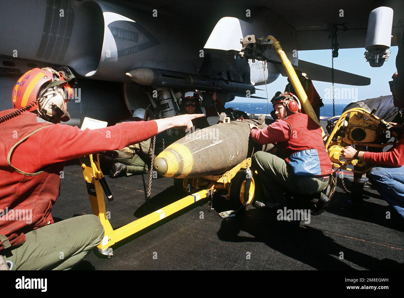 Ordnancemen prepare to upload a bomb on an F/A-18 Hornet aircraft during Operation Desert Storm. Subject Operation/Series: DESERT STORM Country: Unknown Stock Photo