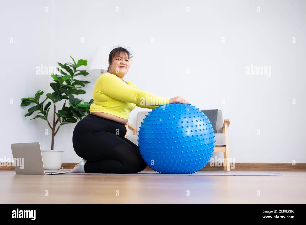 Portrait plus size woman doing exercise with fitness ball in home gym.  Overweight woman sitting on a pilates ball and Stretching her muscles  before ex Stock Photo - Alamy