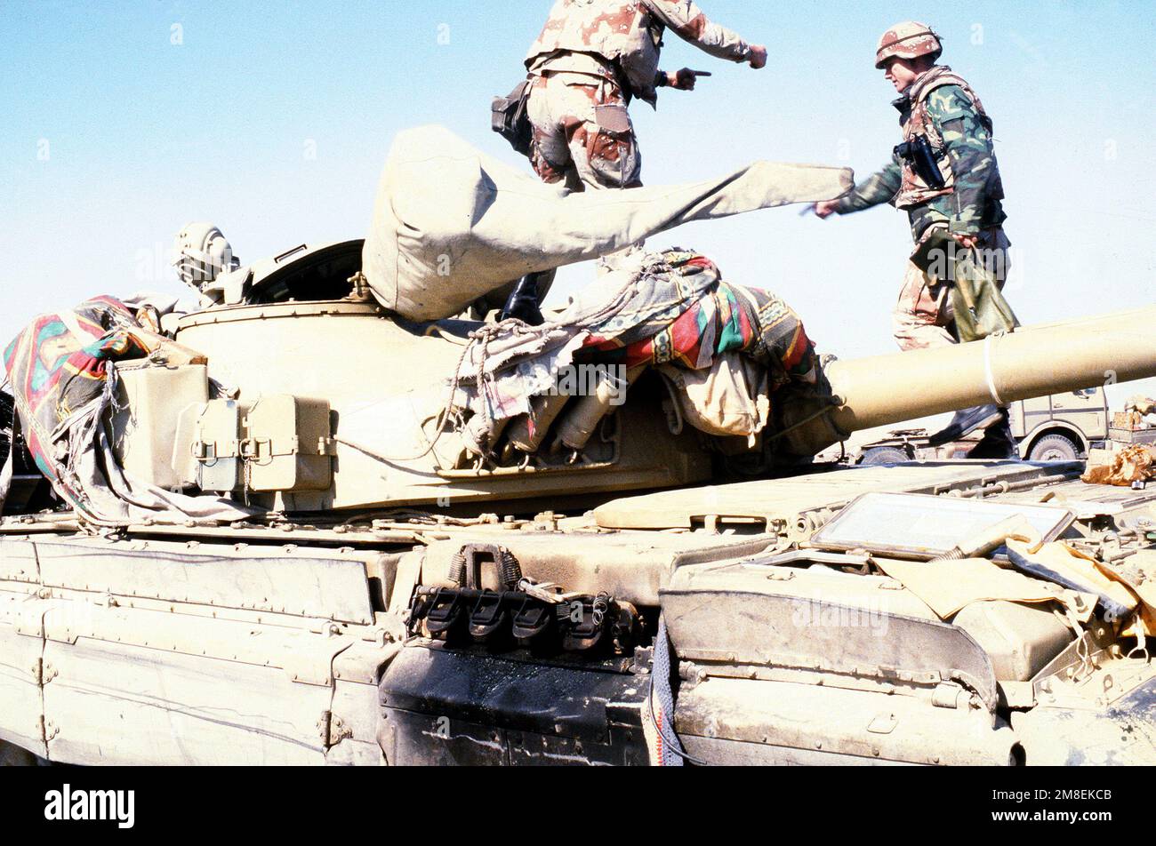 American servicemen examine an Iraqi T72 main battle tank that was