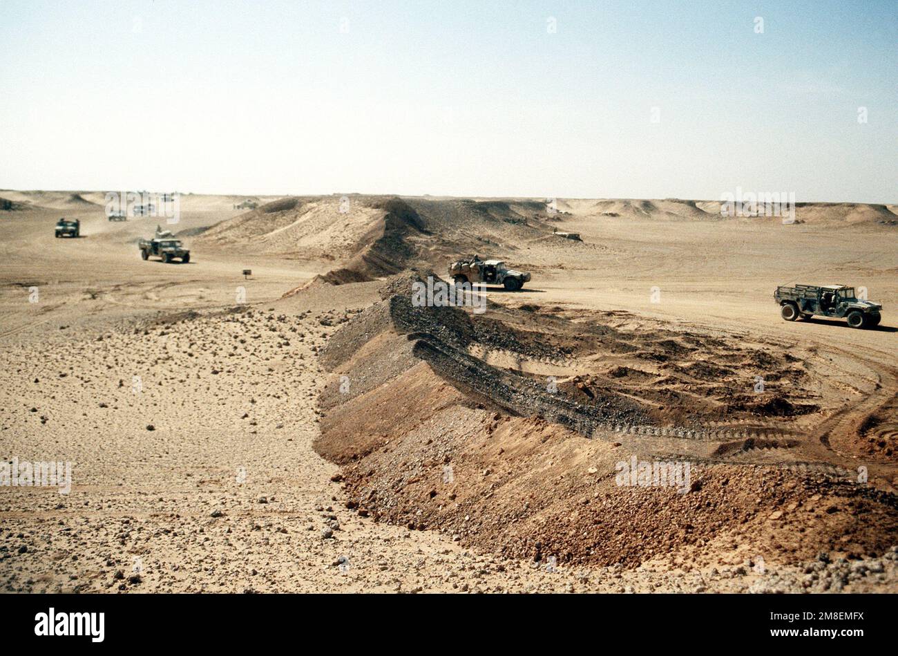 A convoy of M998 highmobility, multipurpose, wheeled vehicles drives