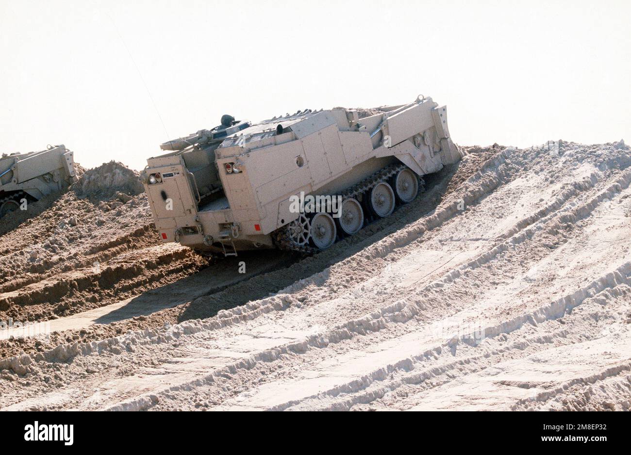 Two M-9 armored combat earthmovers (ACEs) assigned to the 2nd Marine Expeditionary Force level a berm at the Kuwaiti border at the start of the ground phase of Operation DESERT STORM. Subject Operation/Series: DESERT STORM Country: Saudi Arabia (SAU) Stock Photo