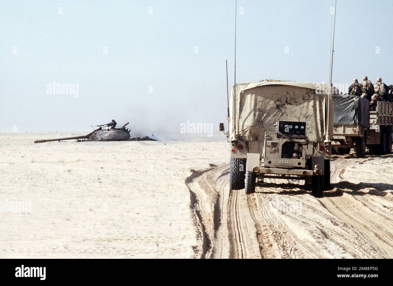 A convoy of trucks from the 2nd Marine Expeditionary Force passes a destroyed Iraqi T-55 main battle tank during the ground phase of Operation Desert Storm. Subject Operation/Series: DESERT STORM Country: Kuwait (KWT) Stock Photo