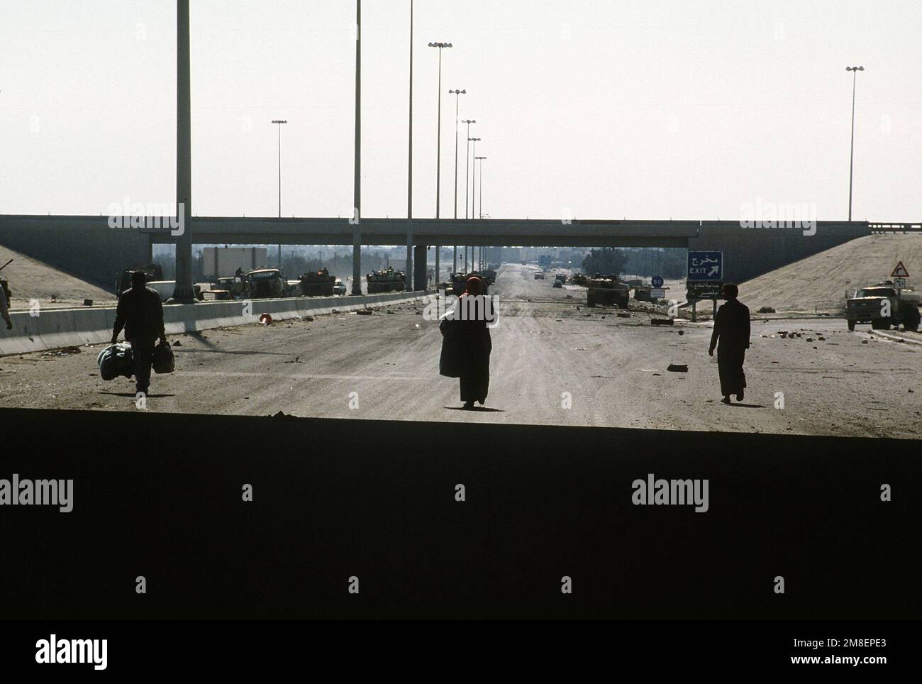 Kuwaiti citizens walk back to the city after hiding from the Iraqi army