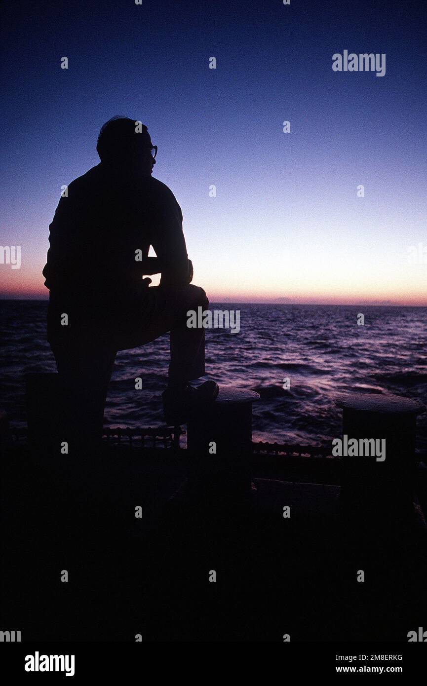 SENIOR CHIEF Machinist's Mate Dennis Cutler watches the sun rise over ...