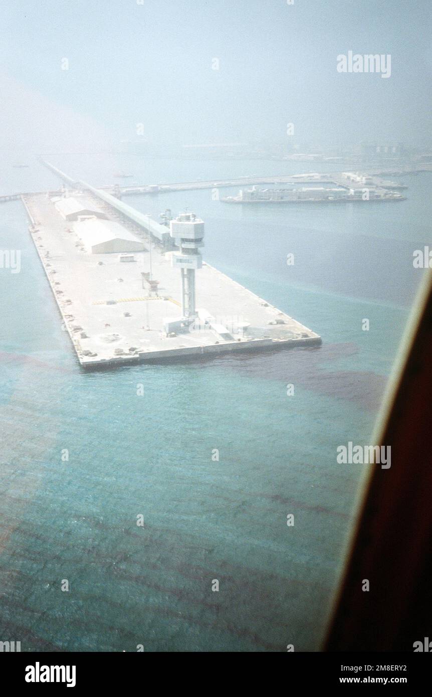 An aerial view of the harbor after mines, planted by Iraqi forces during their occupation of Kuwait, were removed by explosive ordnance disposal (EOD) diving teams. U.S., Australian, and British team members joined in a multinational effort to make the harbor safe for reopening. Oil slicks, also a product of the Iraqi occupation, can be seen in the water. Subject Operation/Series: DESERT SHIELD/STORM Base: Ash Shuaybah Country: Kuwait (KWT) Stock Photo