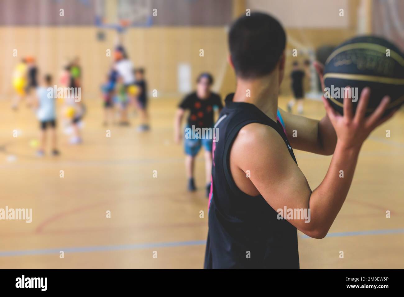 Junior teenage school team of kids children play basketball, players in the hall indoor venue court, sports team during game, playing indoor match gam Stock Photo